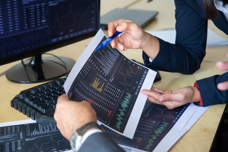 Brokers Discussing Trading Strategy Holding Papers With Financial Data Pointing Pen Charts Cropped Shot Broker Job Stock Market Exchange Concept 74855 14226